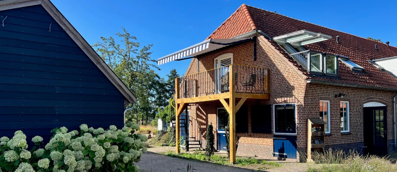 Het vakantieappartement met houten balkon en bloeiende hortensia