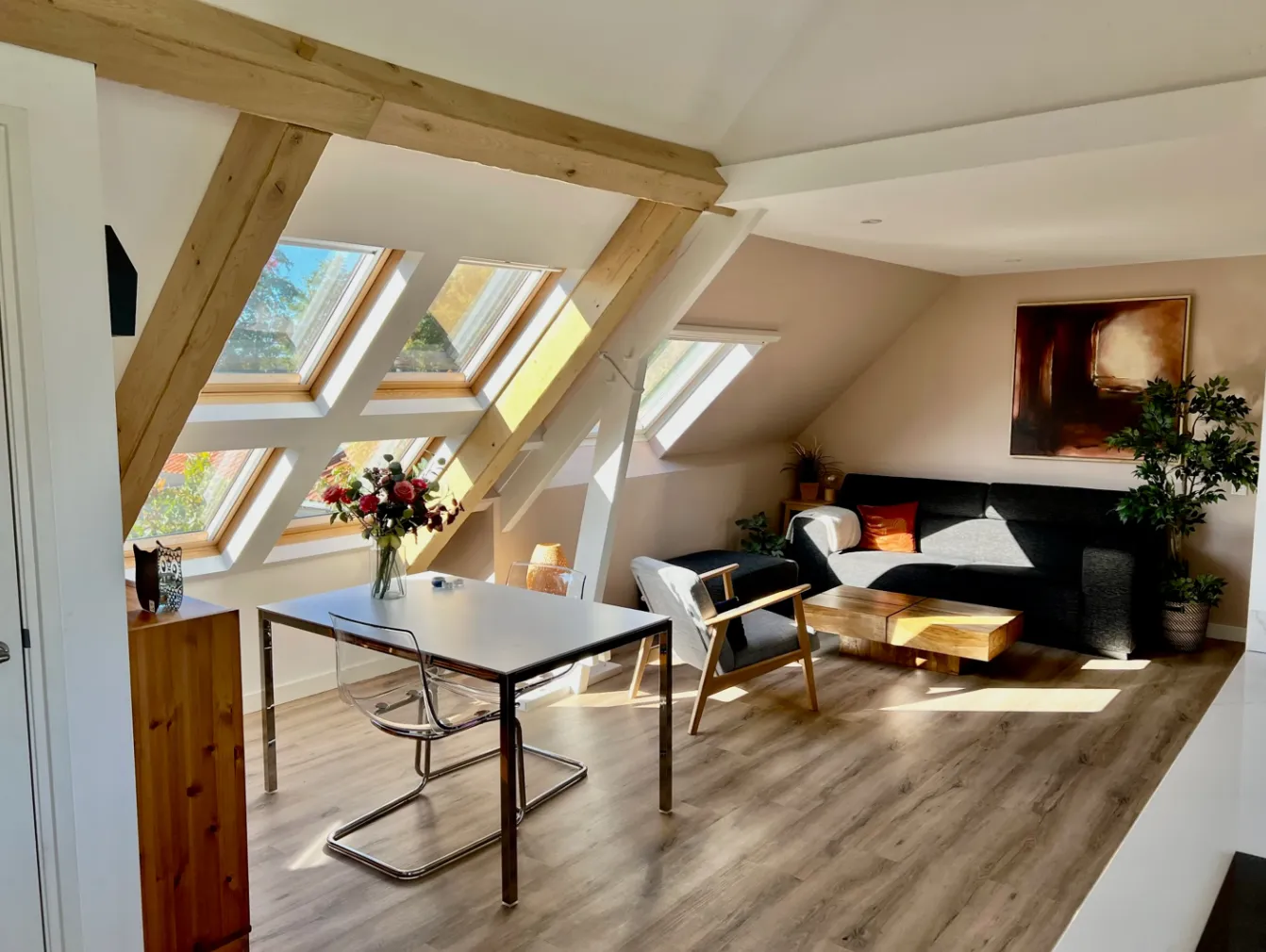 Lichte woonkamer met eettafel onder de dakramen
